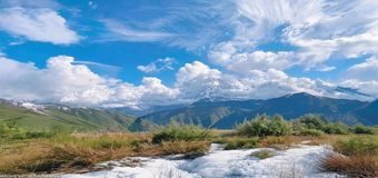 旅行博主在云南香格里拉拍摄雪山草甸风光，天空蔚蓝白云飘逸，画面震撼唯美，旅行视频精选封面